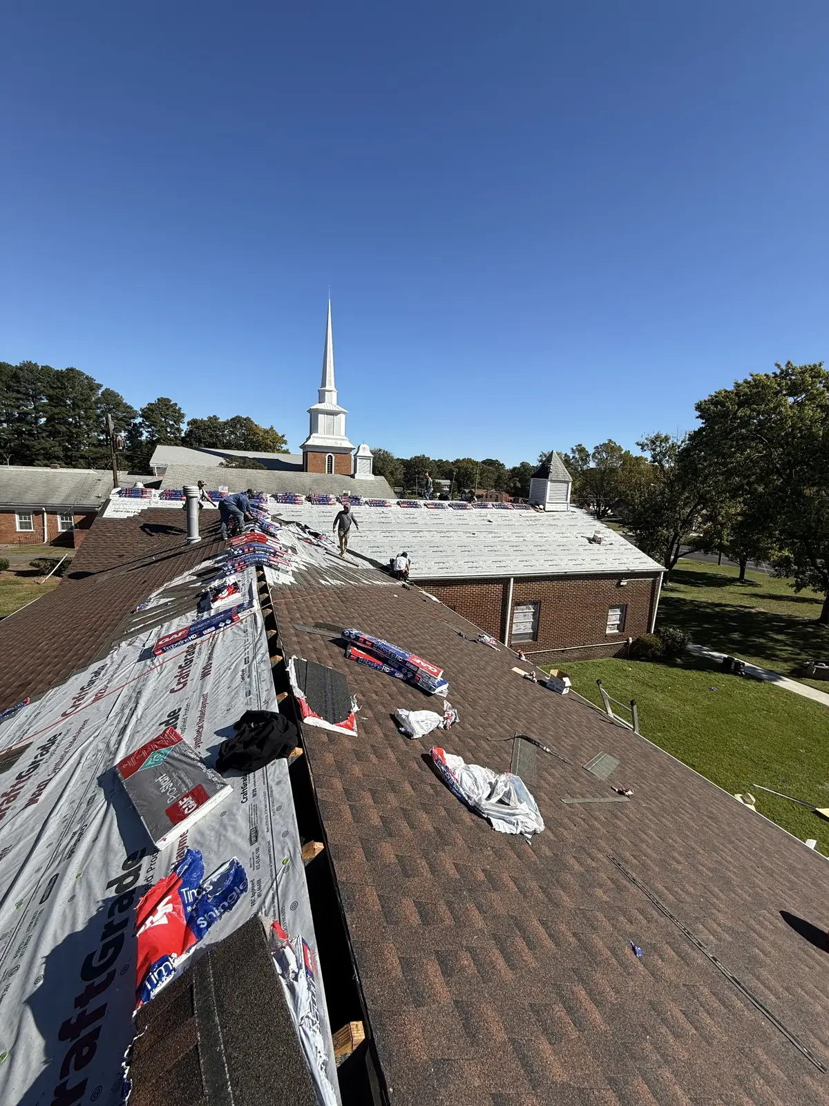 Church re-roof in progress, with the steeple behind the work area