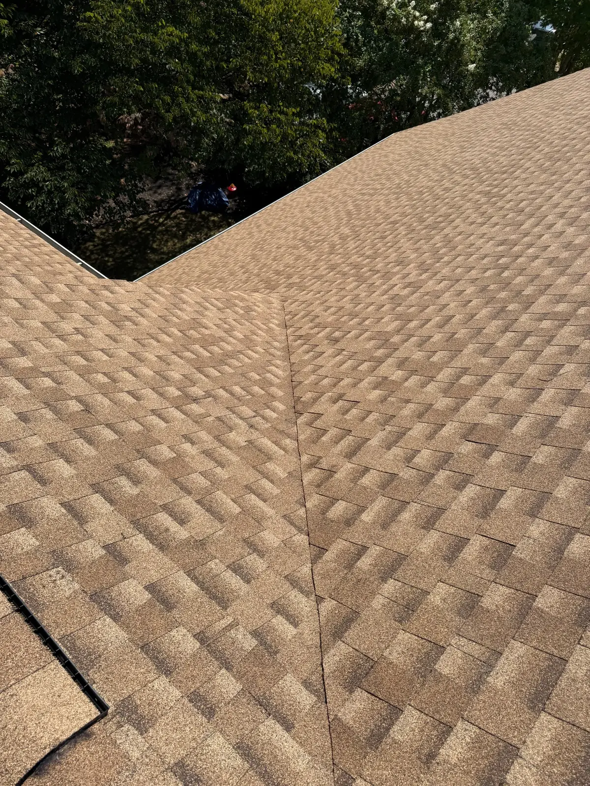 Close view of finished architectural shingles meeting at a hip